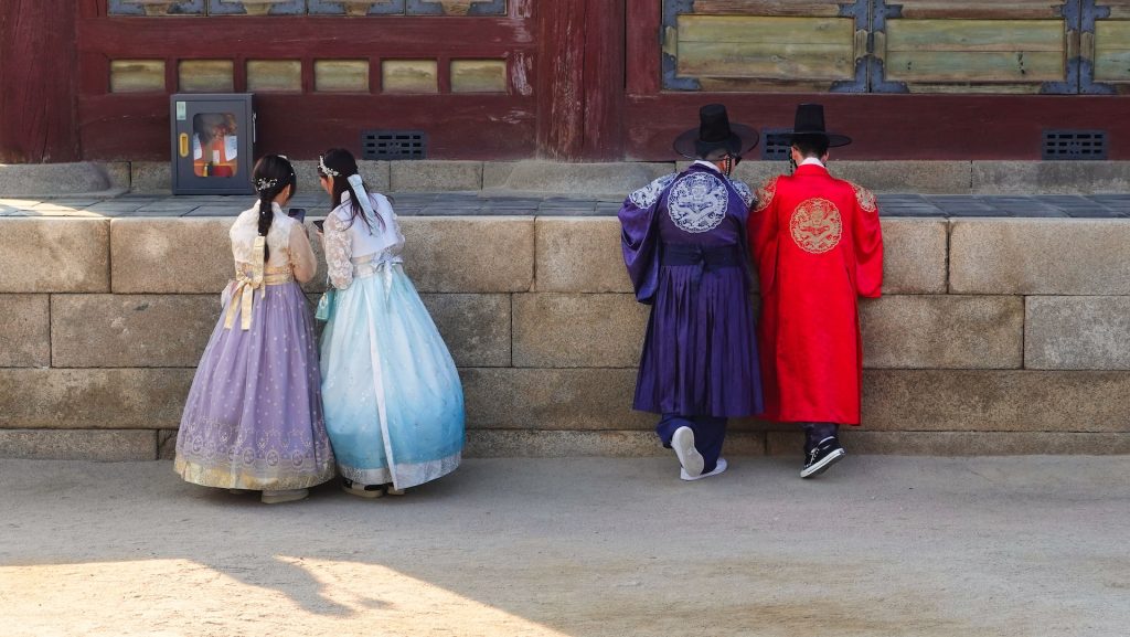 men and women wearing hanbok in gyeongbokgung palace